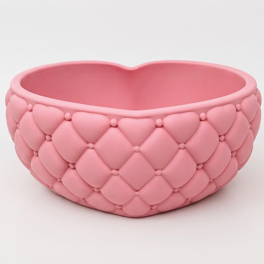 A pink heart-shaped planter with a quilted, tufted texture, shown on a clean white background.